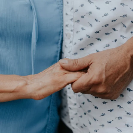 Zwei Personen halten einander Hand. Steht für Unterstützung, Betreuung und generationenübergreifende Fürsorge im Gesundheits- und Sozialbereich.