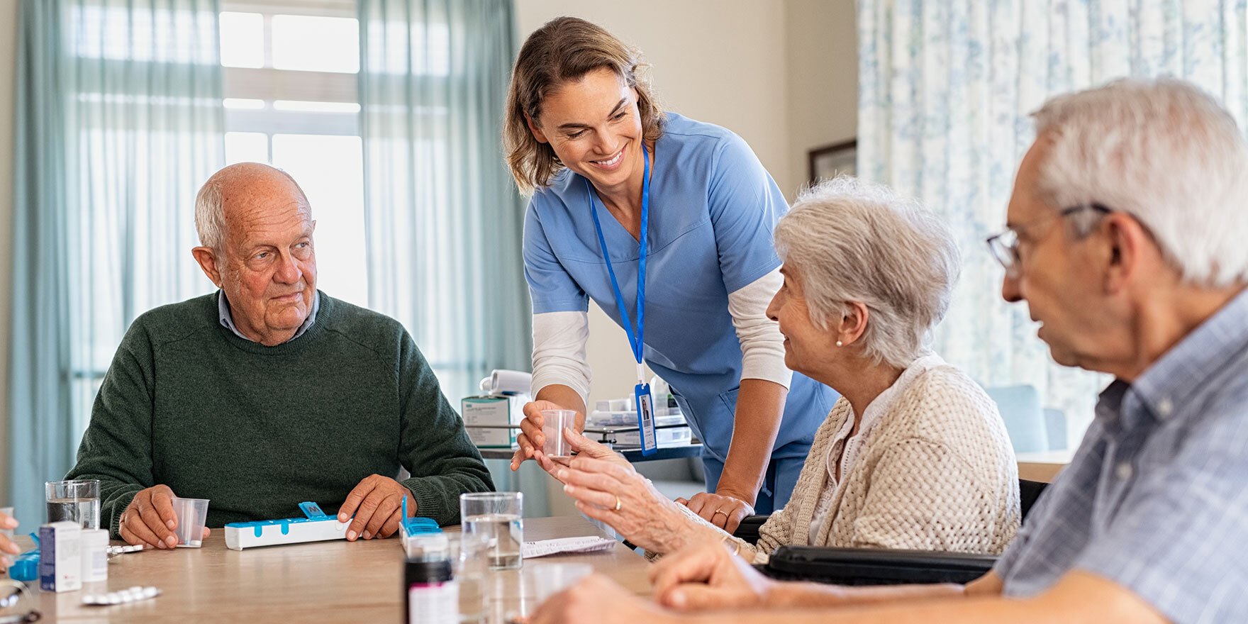 Krankenschwester gibt Medizin an Seniorin in der Pflegeeinrichtung