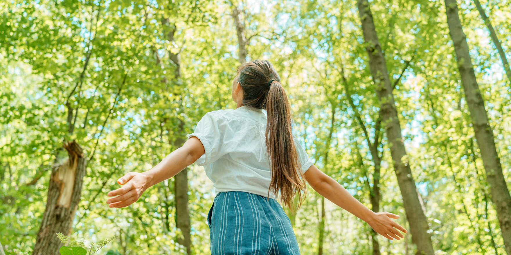 Eine Frau geniest die frische Luft in einem Park