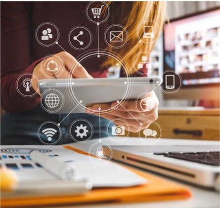 Person mit Tablet, umgeben von digitalen Symbolen für Vernetzung wie E-Mail, Einkaufswagen, WLAN und Smartphone. Symbolisiert digitale Kommunikation im Arbeitsalltag.